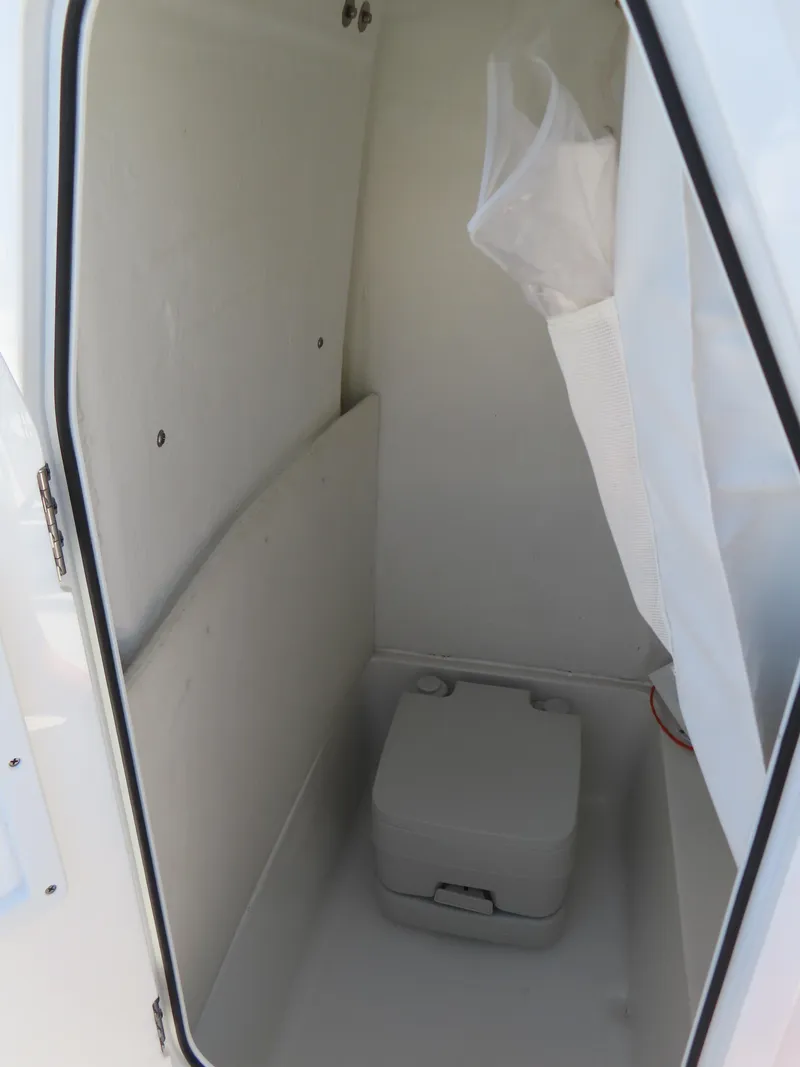 Slide: The Image of 2023 Sea Hunt Ultra 229 boat storage compartment with portable toilet. - 19