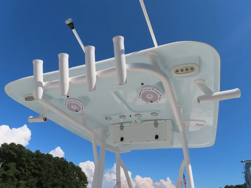 Slide: The Image of 2023 Sea Hunt Ultra 229 boat top view with rod holders and speakers against blue sky. - 28