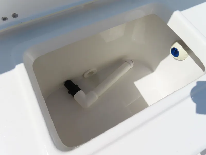 Slide: The Image of Livewell compartment in 2023 Sea Hunt Ultra 229 boat, featuring drainage and plumbing components. - 33