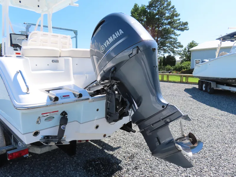 Slide: The Image of 2023 Sea Hunt Ultra 229 boat with Yamaha outboard motor, parked on gravel. - 4