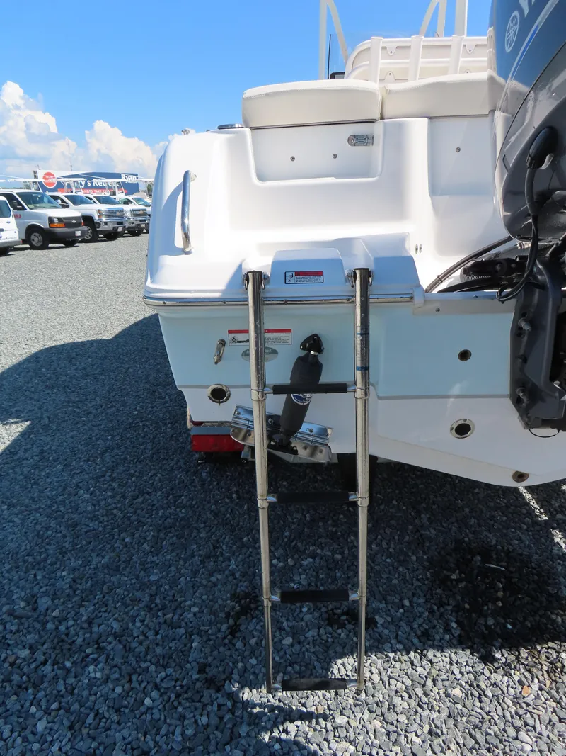 Slide: The Image of 2023 Sea Hunt Ultra 229 boat with ladder on gravel lot. - 5