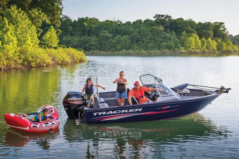 Slide: The Image of 2019 Tracker Pro Guide V-175 Combo boat on a lake with people enjoying tubing. - 33