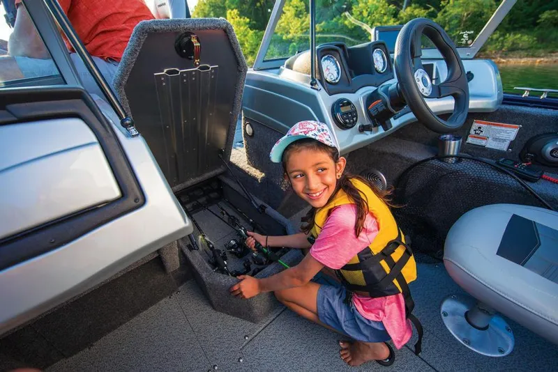 Slide: The Image of Young girl on 2019 Tracker Pro Guide V-175 Combo boat, smiling and exploring storage compartment. - 34