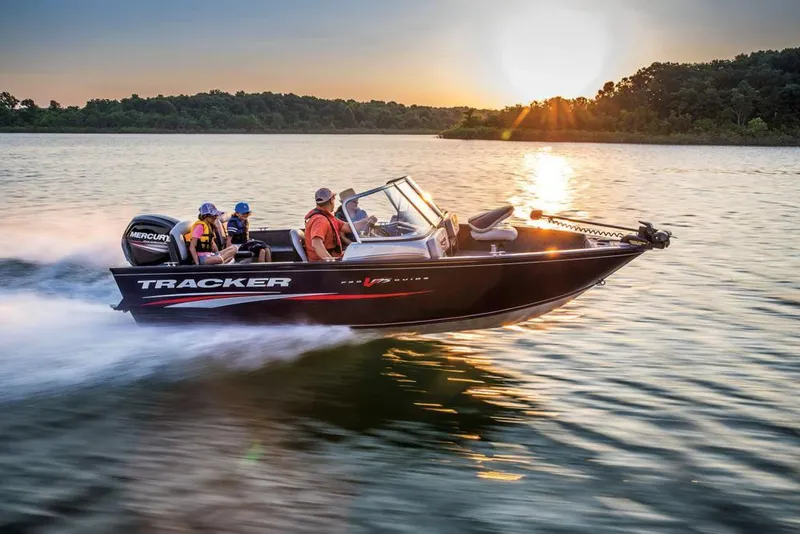 Slide: The Image of 2019 Tracker Pro Guide V-175 Combo boat cruising on a lake at sunset. - 36