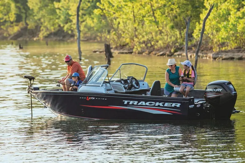 Slide: The Image of 2019 Tracker Pro Guide V-175 Combo boat on a serene lake with passengers. - 42