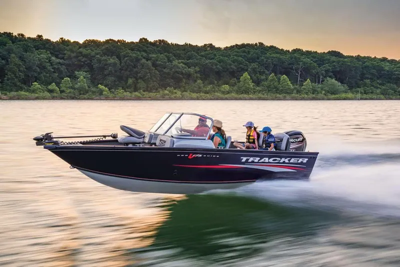 Slide: The Image of 2019 Tracker Pro Guide V-175 Combo boat speeding on a lake at sunset. - 43