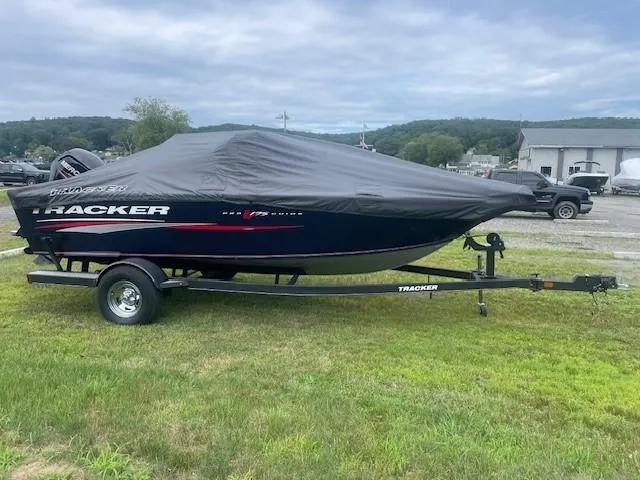 Slide: The Image of 2019 Tracker Pro Guide V-175 Combo boat covered on trailer, parked on grass. - 5