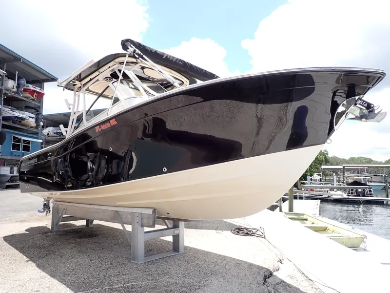 Slide: The Image of 2019 Grady-White Freedom 275 boat on a stand near a marina. - 11