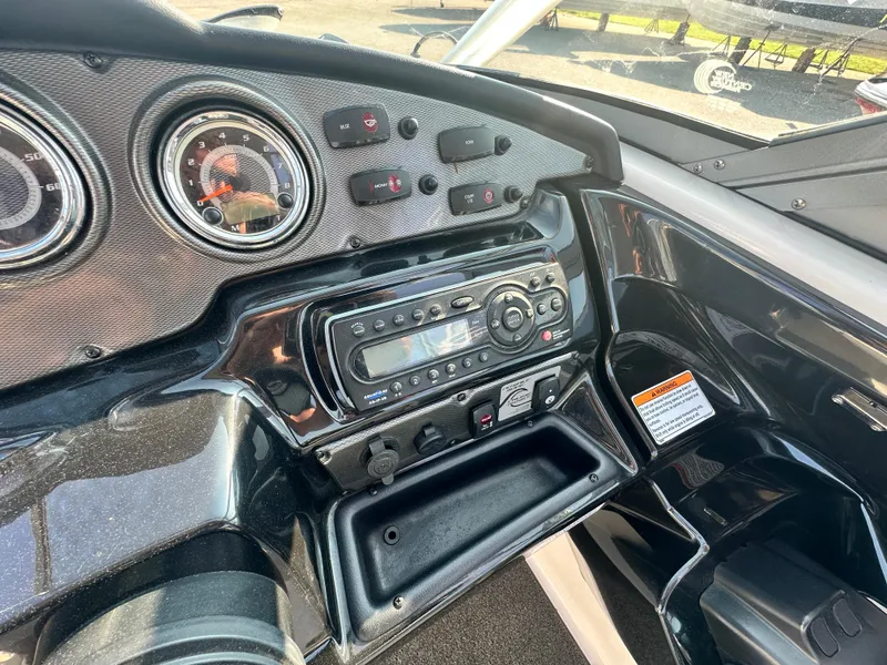 Slide: The Image of Dashboard of a 2012 Yamaha Boats 212X, featuring gauges and a stereo system. - 11