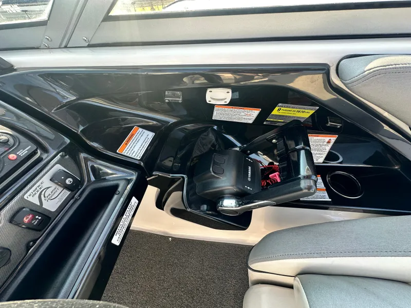 Slide: The Image of Interior view of a 2012 Yamaha Boats 212X dashboard with control panel and safety labels. - 12