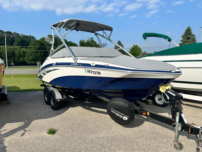 Slide: The Image of 2012 Yamaha Boats 212X on trailer, parked outdoors under a clear blue sky. - 19
