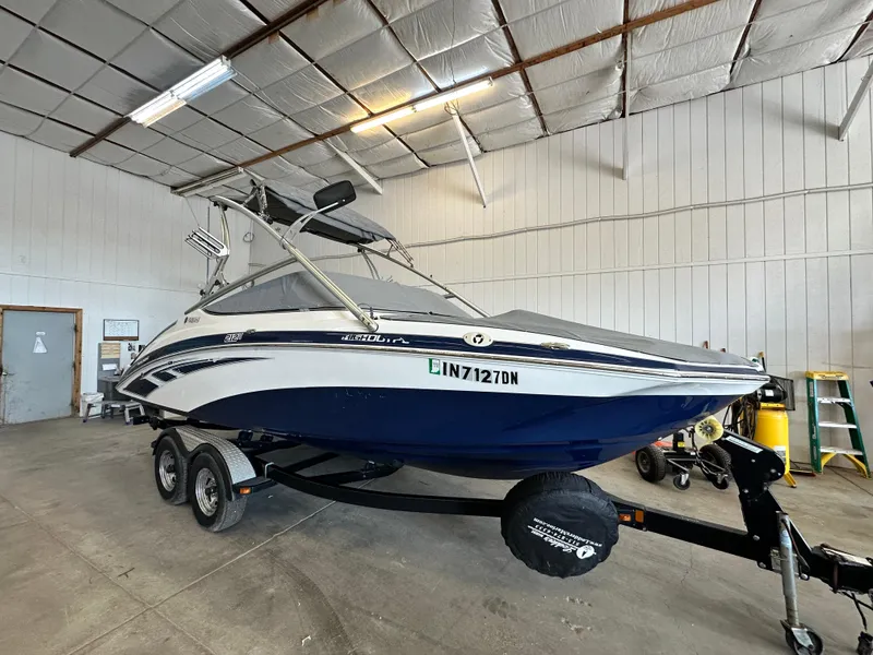 Slide: The Image of 2012 Yamaha Boats 212X in a garage, blue and white, on a trailer. - 3