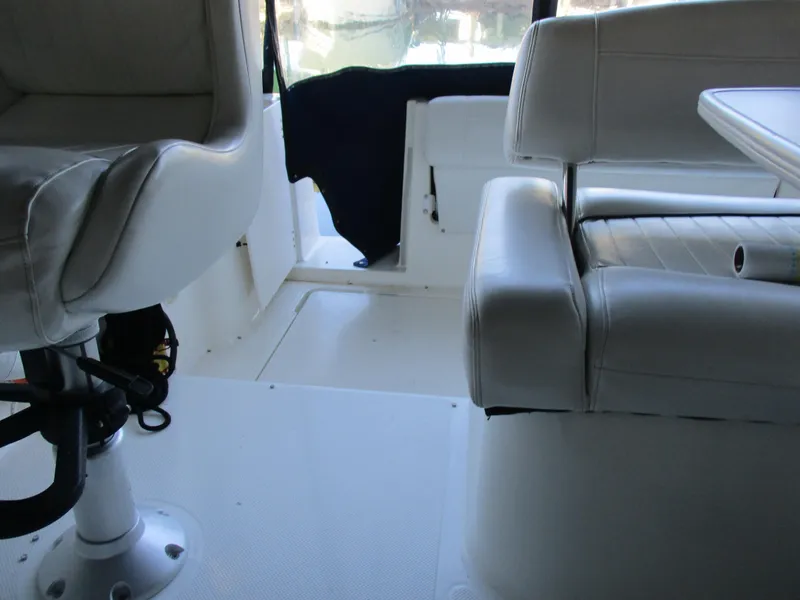 Slide: The Image of Interior of 1998 Bayliner 2855 Ciera Sunbridge with white seating and helm chair. - 14