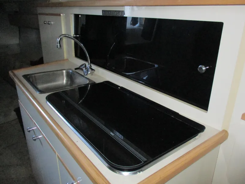 Slide: The Image of 1998 Bayliner 2855 Ciera Sunbridge kitchen area with sink and stove. - 18