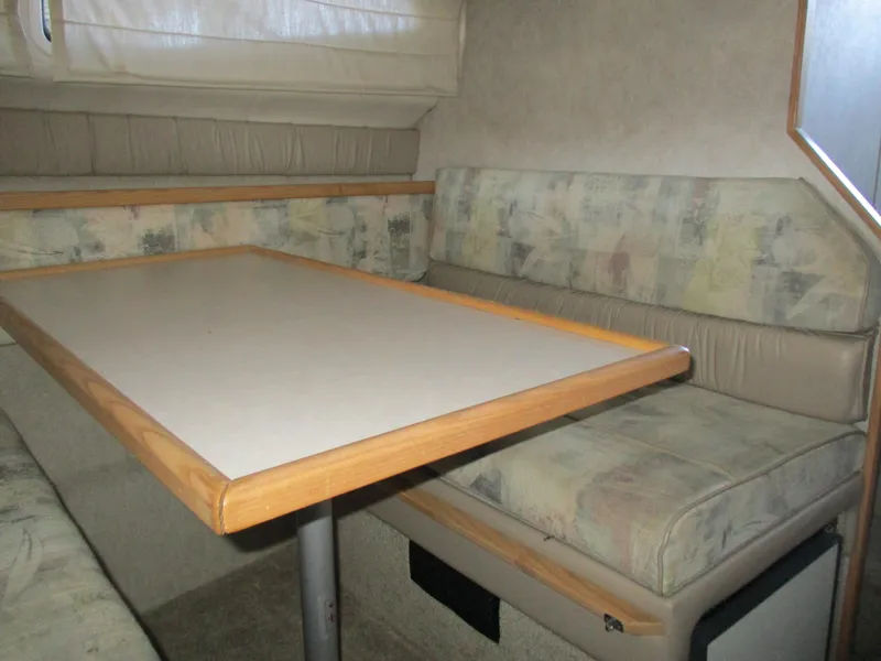 Slide: The Image of 1998 Bayliner 2855 Ciera Sunbridge interior with dining area and cushioned seating. - 19