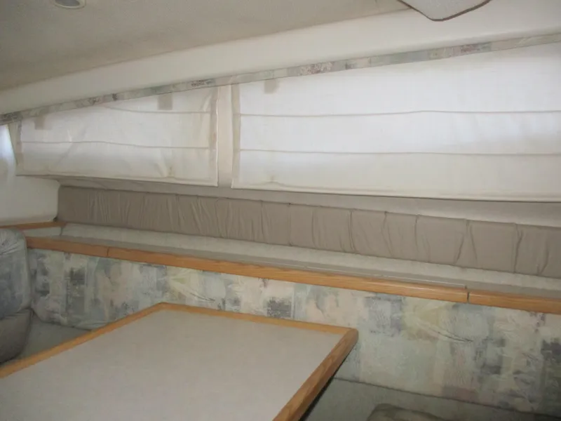 Slide: The Image of Interior of 1998 Bayliner 2855 Ciera Sunbridge with cushioned seating and table. - 20