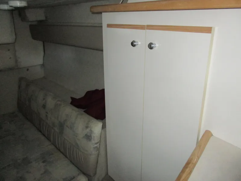 Slide: The Image of Interior of 1998 Bayliner 2855 Ciera Sunbridge, featuring a cozy cabin with seating and storage. - 24