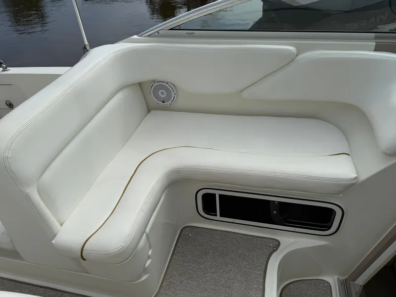 Slide: The Image of 2002 Sea Ray 260 Sundancer boat interior with white cushioned seating. - 6