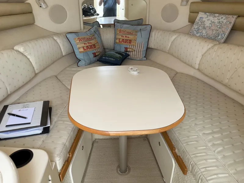 Slide: The Image of Interior of 2002 Sea Ray 260 Sundancer with cozy seating and decorative pillows. - 9