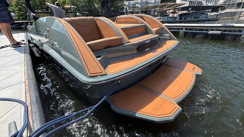 Slide: The Image of 2025 MB B52 25 Alpha boat docked, featuring sleek design and wooden deck accents. - 12