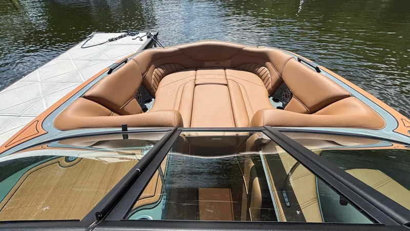 Slide: The Image of 2025 MB B52 25 Alpha boat with tan leather seating, docked on calm water. - 23