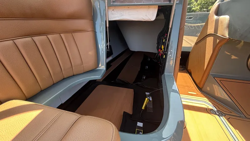 Slide: The Image of 2025 MB B52 25 Alpha interior with tan leather seats and storage compartment. - 25