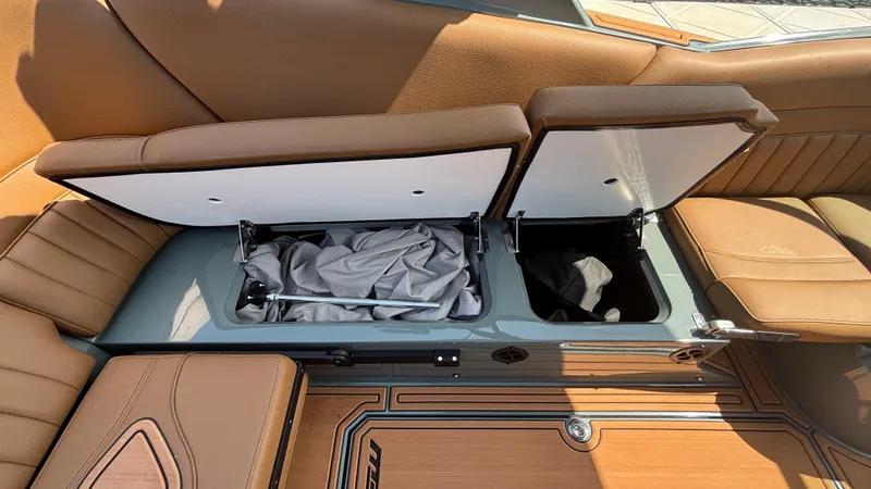 Slide: The Image of Open storage compartments in a 2025 MB B52 25 Alpha boat with brown seating. - 28