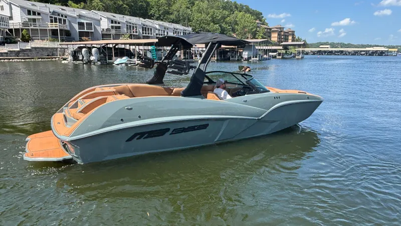 Slide: The Image of 2025 MB B52 25 Alpha boat on a lake near waterfront homes. - 3