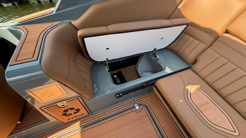 Slide: The Image of 2025 MB B52 25 Alpha boat interior with open storage compartment and tan leather seating. - 30
