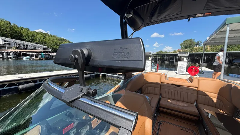 Slide: The Image of 2025 MB B52 25 Alpha boat interior with tan seating at a marina dock. - 41