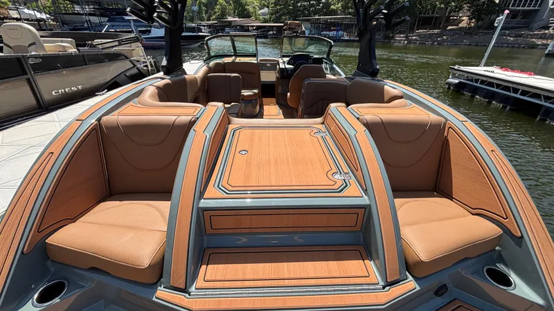 Slide: The Image of 2025 MB B52 25 Alpha boat with luxurious tan seating and sleek design on a sunny dock. - 49