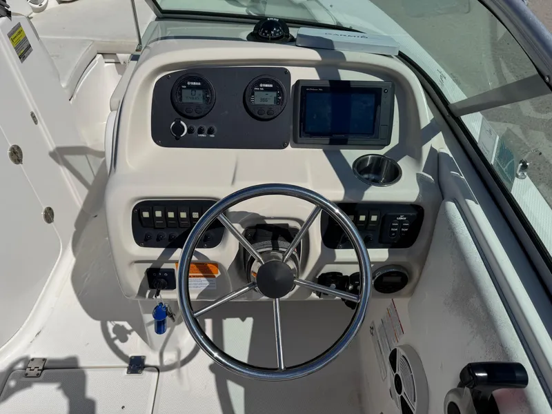 Slide: The Image of 2014 Robalo R207 Dual Console boat dashboard with steering wheel and navigation instruments. - 16