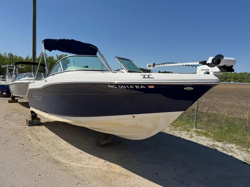 Slide: The Image of 2014 Robalo R207 Dual Console boat on dry land, blue and white exterior. - 4