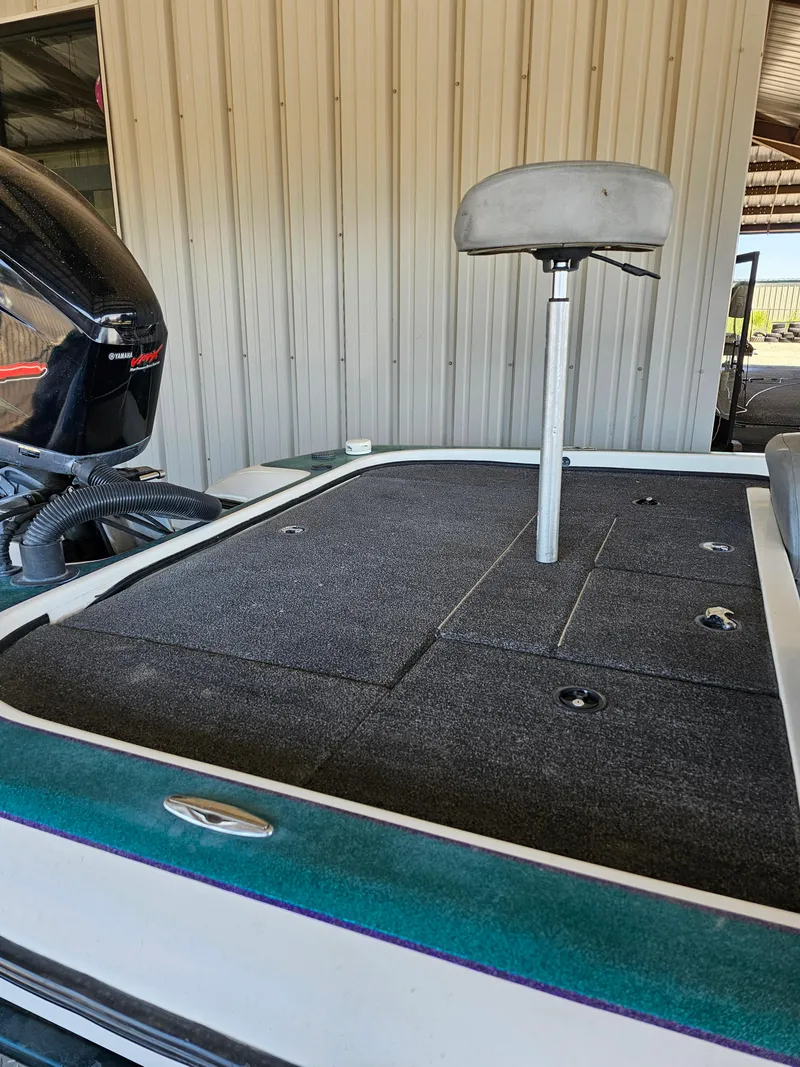 Slide: The Image of 2005 Blazer 202 Pro-V boat deck with seat and motor in a garage setting. - 9