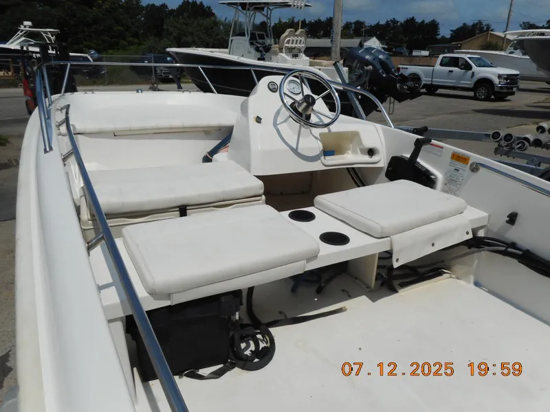 Slide: The Image of 2010 Boston Whaler 150 Super Sport boat interior with seating and steering wheel. - 5