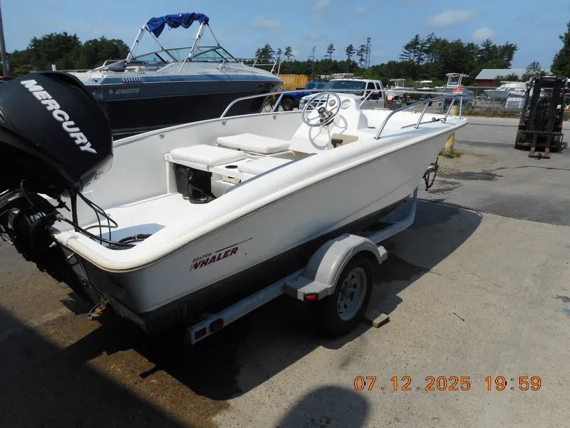 Slide: The Image of 2010 Boston Whaler 150 Super Sport boat on trailer, parked outdoors. - 7