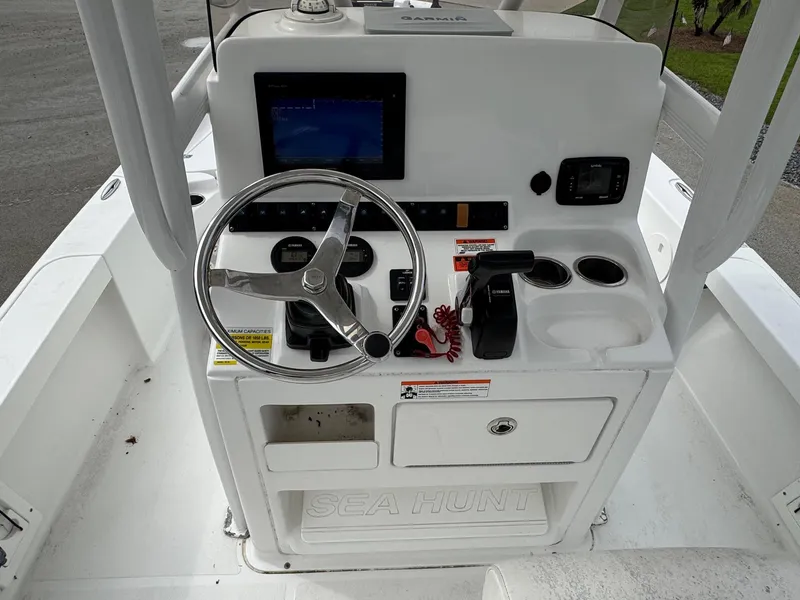 Slide: The Image of 2016 Sea Hunt BX22 boat console with steering wheel, controls, and navigation display. - 14