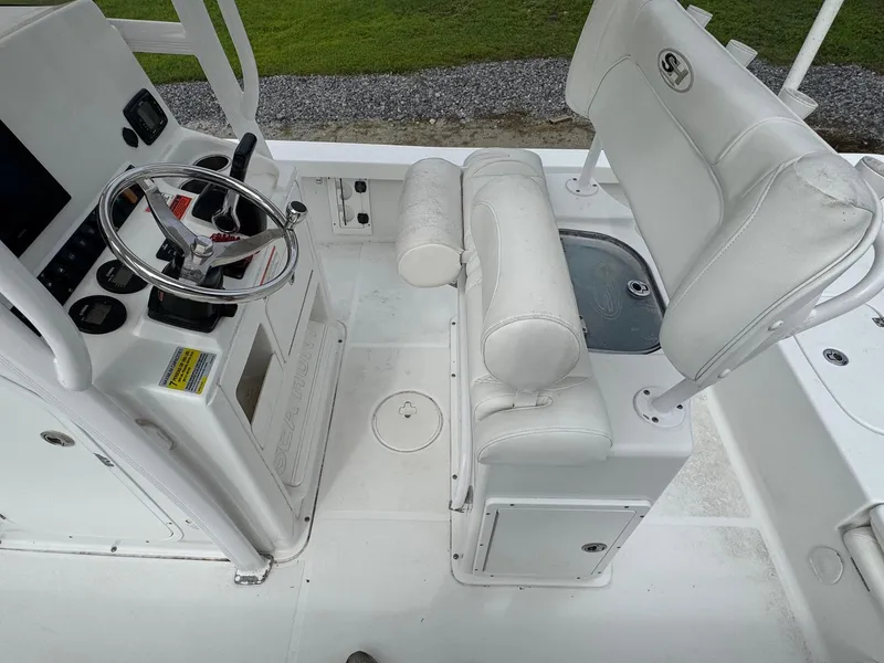 Slide: The Image of 2016 Sea Hunt BX22 boat interior with steering console and cushioned seating. - 17