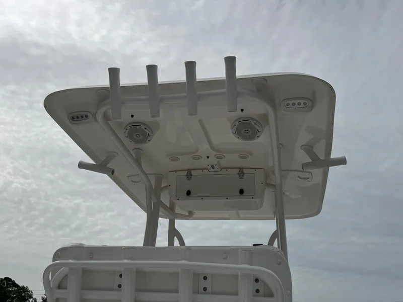 Slide: The Image of 2016 Sea Hunt BX22 boat T-top with rod holders against cloudy sky. - 25