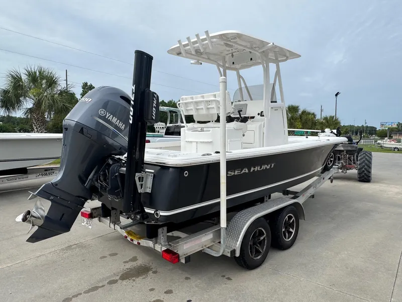 Slide: The Image of 2016 Sea Hunt BX22 boat on trailer with Yamaha outboard motor, parked outdoors. - 6
