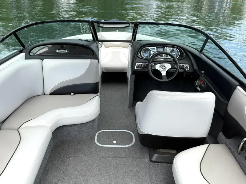 Slide: The Image of Interior of a 2012 Malibu 21 Ride boat with sleek seating and modern dashboard. - 7