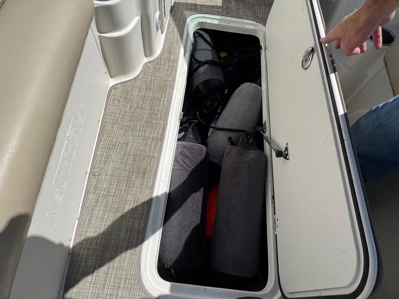 Slide: The Image of Open storage compartment on 2017 NauticStar 203 DC boat, showing interior contents. - 15
