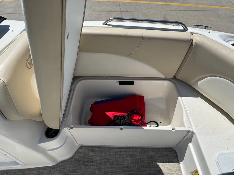 Slide: The Image of 2017 NauticStar 203 DC boat storage compartment with red and blue life jacket and rope. - 16