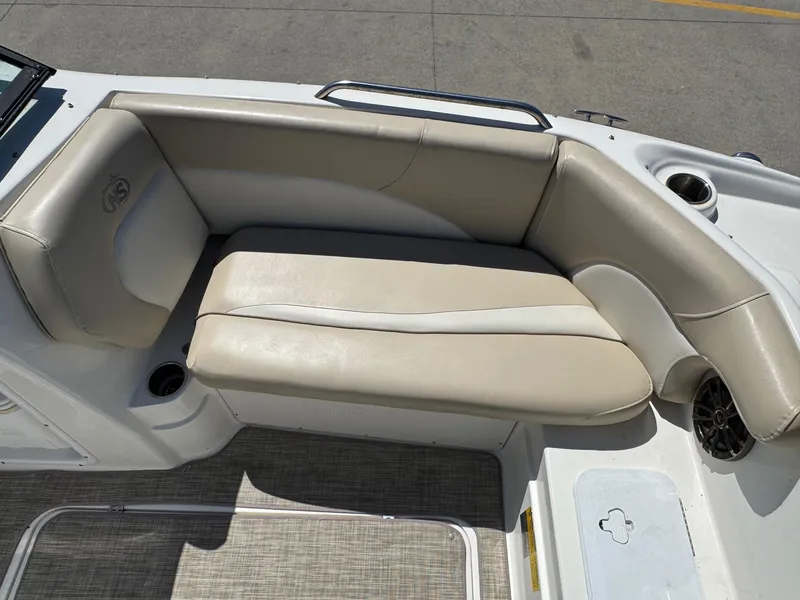 Slide: The Image of 2017 NauticStar 203 DC boat interior seating with beige upholstery and cup holders. - 17