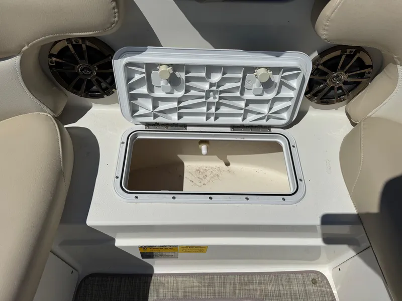 Slide: The Image of Open storage compartment on 2017 NauticStar 203 DC boat, surrounded by beige seating. - 18