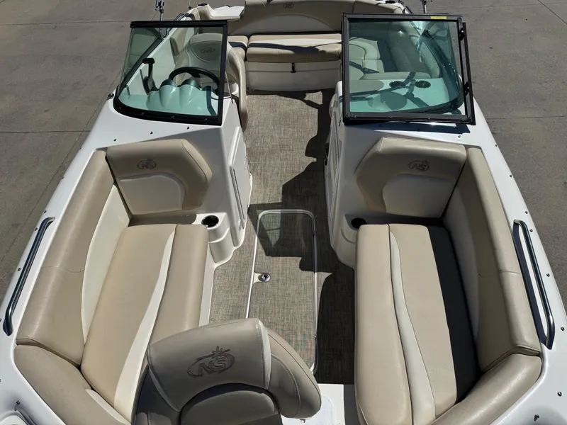 Slide: The Image of 2017 NauticStar 203 DC boat interior with beige seating and open windshield. - 19