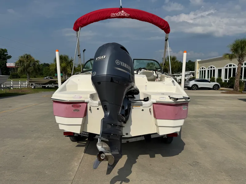 Slide: The Image of 2017 NauticStar 203 DC boat with Yamaha 150 engine, parked outdoors. - 4