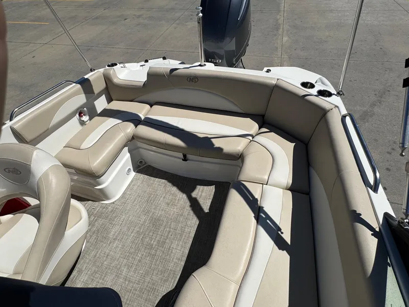 Slide: The Image of 2017 NauticStar 203 DC boat interior with beige seating and carpeted floor. - 8