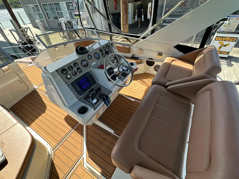 Slide: The Image of 1996 Carver 38 Santego boat helm with leather seating and modern controls at a dock. - 15
