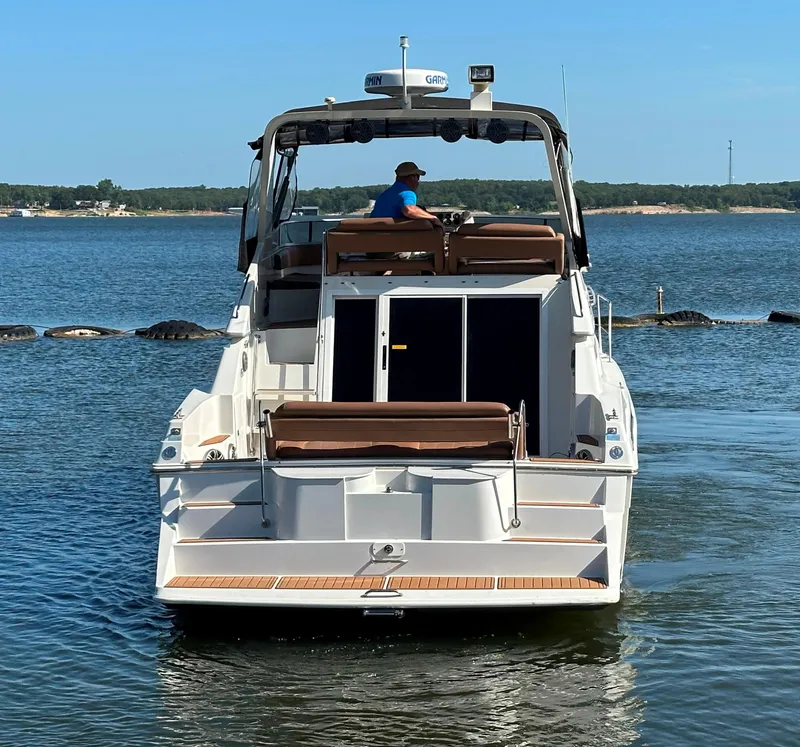 Slide: The Image of 1996 Carver 38 Santego yacht on calm water, rear view with person at helm. - 5